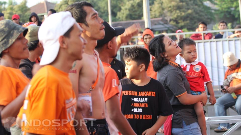 Tampak juga seorang ibu menggendong anaknya yang berpakaian Persija.